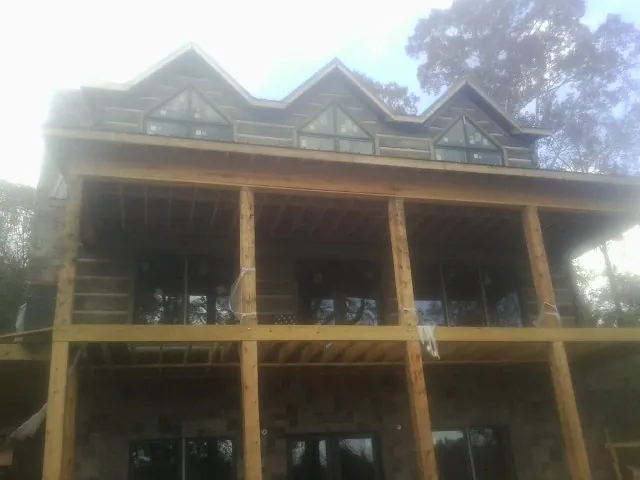 Dormers and porch framing on a large log home under construction — Roof Coating work by our crew in Rapid City